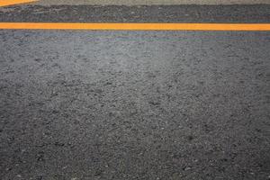 fondo di struttura della strada asfaltata con la linea tratteggiata gialla foto