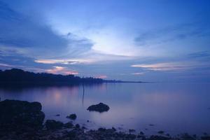 incredibile vista sul mare in una spiaggia di sumatera. spiaggia con rocce accanto. scattare con una bassa velocità dell'otturatore o messa a fuoco morbida. riflesso della foresta accanto alla spiaggia sotto il cielo blu. foto