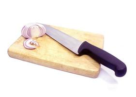 cipolle e un grosso coltello su un macellaio foto