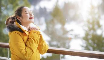 grindelwald svizzera cima d'europa, donna asiatica che indossa un cappotto giallo. usa lo smartphone scatta una foto montagna di neve nella sua vacanza in montagna, viaggio inverno nevoso sul monte a grindelwald.