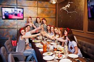 ragazze favolose che posano con i cupcakes nel ristorante all'addio al nubilato. foto