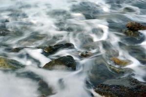 turbolenza acqua di mare e roccia sulla costa foto