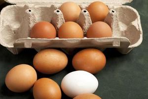 vista ravvicinata di uova di pollo crude marroni e bianche in scatola, bianco d'uovo, marrone d'uovo foto