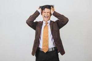giovane uomo d'affari asiatico stressato che ha mal di testa e si sente sconvolto foto