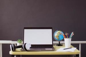 laptop con schermo vuoto con accessori e stazionario sulla scrivania in legno