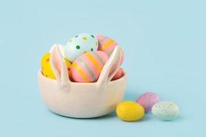 Buona Pasqua. uova colorate di Pasqua dipinte in una ciotola di orecchie di coniglio foto