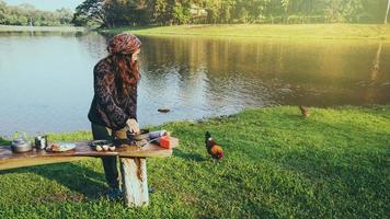 donna turistica naturale, sta facendo colazione, mangiando cibo. viaggio in campeggio, viaggio in campeggio sul lago. i campeggiatori sono nel loro campo alla cascata del parco nazionale di namtok sam lan foto