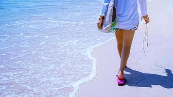 le donne asiatiche viaggiano nella natura. viaggiare rilassati. gioca con l'acqua di mare sulla spiaggia. in estate. Tailandia foto