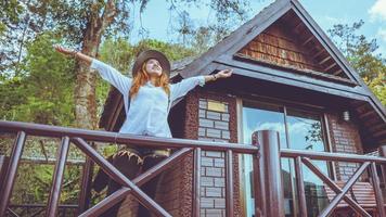 il viaggio della donna asiatica si rilassa. parco naturale sulla montagna. stare sul balcone della loggia. foto