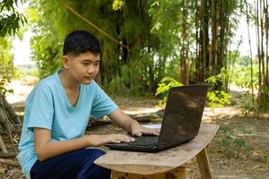 un ragazzo si concentra sullo studio online con un computer portatile a casa in campagna foto