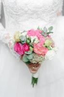 ritratto di una giovane bella sposa nella città vecchia. nelle mani di una ragazza con in mano un bouquet da sposa. foto