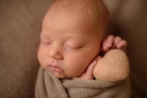 neonata che dorme con un cuore secco nelle sue mani. foto