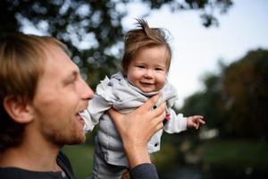 giovane padre che si diverte con la sua piccola figlia nel parco foto