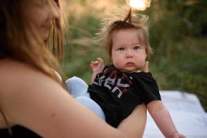 giovane madre che abbraccia il bambino carino all'aperto foto