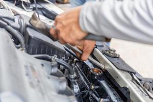 meccanico che fissa il sistema dell'acqua di raffreddamento al motore dell'auto, concetto di riparazione dell'auto foto