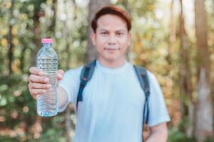 turista maschio che trasporta una bottiglia d'acqua foto