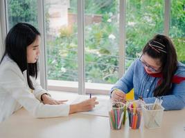 un'allegra lezione di arti creative di gruppo per bambini e il loro insegnante nell'aula scolastica, scolari felici che giocano a un interessante gioco da tavolo durante una lezione in classe foto