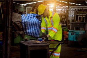 ingegneria industriale e lavoro di squadra che indossano controllo uniforme di sicurezza che opera la rettificatrice del tornio che lavora nella fabbrica industriale. foto