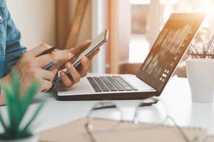 lavoro utilizzando il telefono cellulare digitando computer mobile chat laptop contattaci nei luoghi di lavoro, pianificazione idee investitori ricerca su Internet, idee che collegano le persone. foto