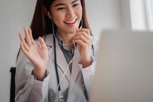 la dottoressa asiatica è online in visita con un paziente sull'applicazione Internet e ascolta i sintomi e spiega come trattare la malattia iniziale, concetto di tecnologia medica. foto