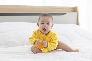 i bambini asiatici stanno giocando a giocattoli per bambini a letto. foto