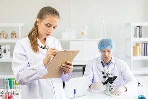 scienziati, giovani uomini e donne in laboratorio e hanno una bella luce arancione. foto