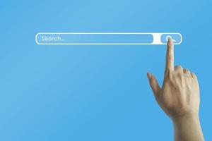 mano con un tocco del dito sul simbolo di ricerca su Internet per la ricerca dei dati informativi su sfondo blu. foto