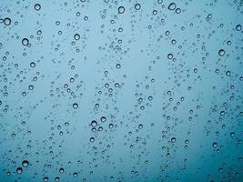 gocce di pioggia del primo piano sull'auto di vetro nella stagione delle piogge. foto