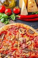 pizza italiana e ingredienti su fondo di legno, vista dall'alto foto