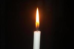 candele di luce in una fitta oscurità foto