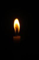 candele di luce in una fitta oscurità foto