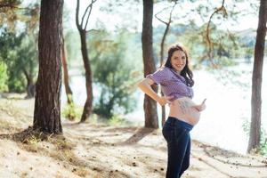 donna incinta che tiene le mani sullo stomaco foto