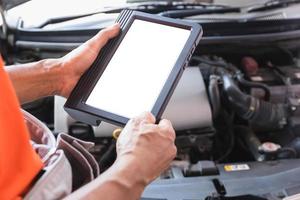 i meccanici stanno esaminando l'auto mentre lavorano nel servizio di auto, il tecnico sta facendo la lista di controllo per la riparazione del motore dell'auto nel garage foto