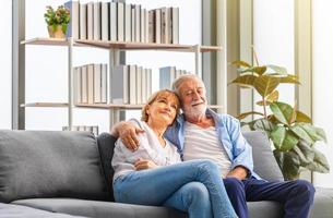 felice coppia senior in soggiorno, donna anziana e un uomo che si rilassa sull'accogliente divano a casa, concetti di famiglia felici foto
