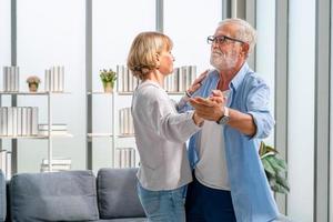 ritratto di felice coppia senior che balla in soggiorno, donna anziana e un uomo che balla, concetti di famiglia felice foto