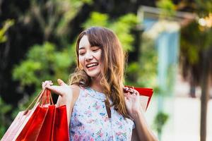 la giovane donna asiatica tiene la borsa rossa al centro commerciale. foto