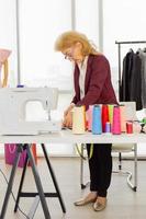 designer di cucito femminili professionisti in ufficio hanno una varietà di combinazioni di colori di tessuto. foto