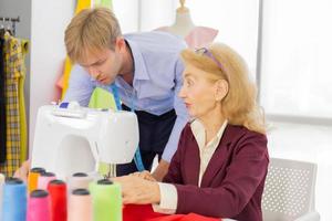 designer professionisti, giovani uomini e donne anziane in ufficio con una varietà di tonalità di tessuto e accessori per vari modelli. foto