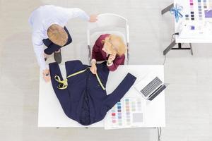 topview professionisti del lavoro di squadra designer, giovani uomini e donne anziane in ufficio con una varietà di tonalità di tessuto e attrezzature per vari design. foto