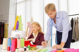 designer professionisti, giovani uomini e donne anziane in ufficio con una varietà di tonalità di tessuto e accessori per vari modelli. foto