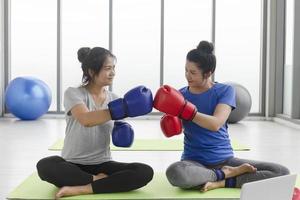 due donne asiatiche di mezza età che fanno esercizi di boxe in palestra. foto