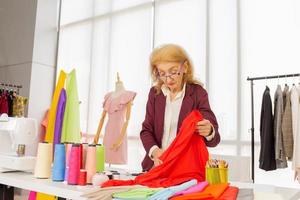 designer di cucito femminili professionisti in ufficio hanno una varietà di combinazioni di colori di tessuto. foto