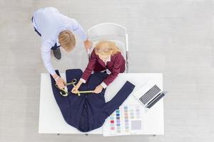 topview professionisti del lavoro di squadra designer, giovani uomini e donne anziane in ufficio con una varietà di tonalità di tessuto e attrezzature per vari design. foto