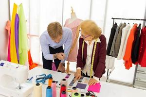 la stilista senior donna consiglia ai clienti maschi di utilizzare il servizio di sartoria dell'abito. foto