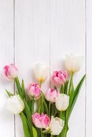 bei tulipani su fondo di legno bianco. umore primaverile foto