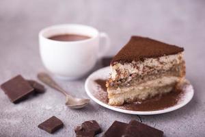 tiramisù dolce tradizionale italiano. pezzo su piatto bianco foto