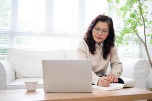 immagine della donna d'affari asiatica senior che lavora a casa foto