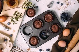 cupcakes con crema e mirtilli sul tavolo della cucina foto