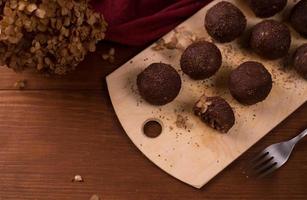 palline di cacao, torte al tartufo di cioccolato a bordo su fondo di legno foto