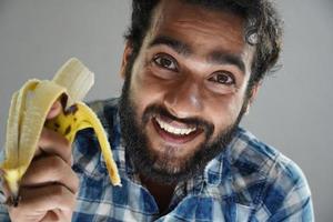 uomo che mangia banana e felice foto